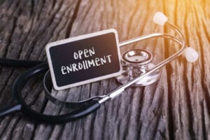 Chalkboard saying "Open Enrollment" with Stethescope
